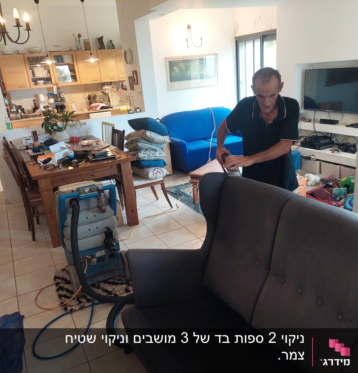 אדם מנקה ספה עם מכונת ניקוי בבית